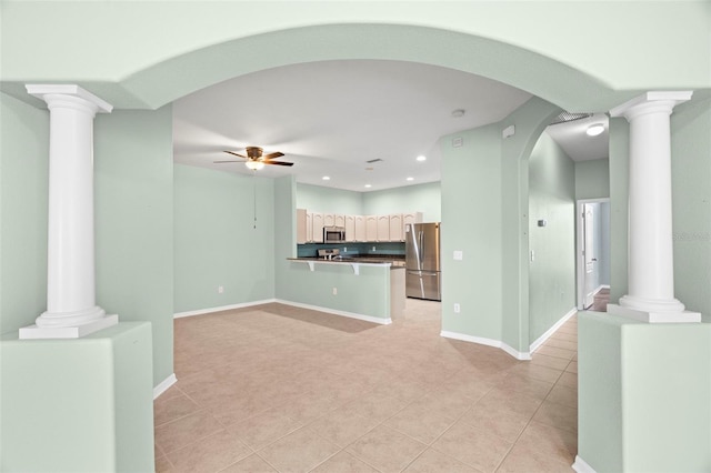 19232 Barred Owl Ct, Land O Lakes, FL 34638 - unfurnished living room with decorative columns, ceiling fan, light tile patterned floors, arched walkways, and recessed lighting