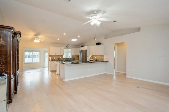 kitchen with ceiling fan, freestanding refrigerator, white cabinets, vaulted ceiling, and dark countertops