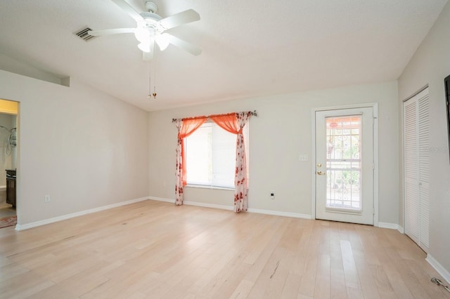 spare room with light wood finished floors, visible vents, baseboards, and a ceiling fan