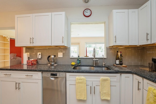 kitchen featuring stainless steel dishwasher, white cabinets, and a sink