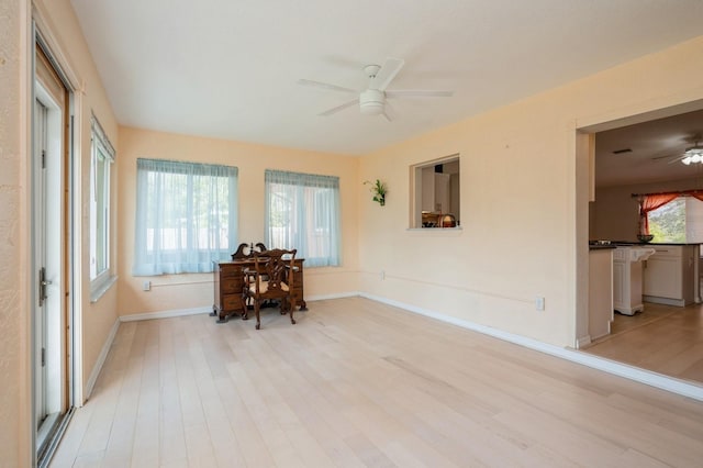 empty room with light wood-style flooring, ceiling fan, and baseboards