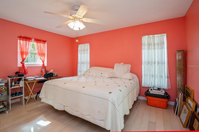 bedroom featuring wood finished floors, baseboards, and a ceiling fan