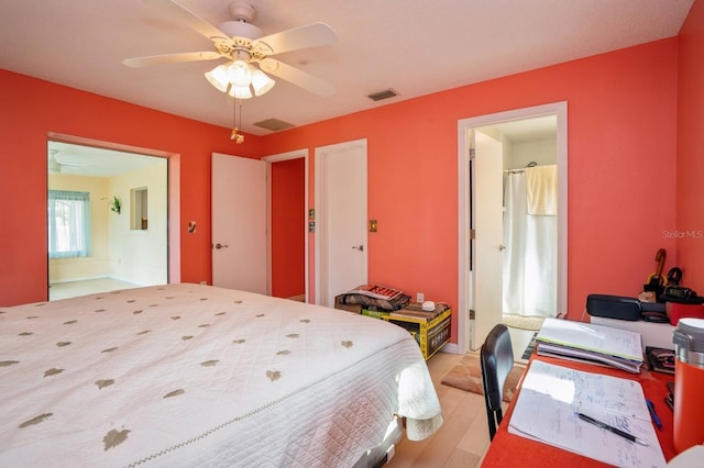 bedroom with light wood-style floors, ceiling fan, visible vents, and connected bathroom
