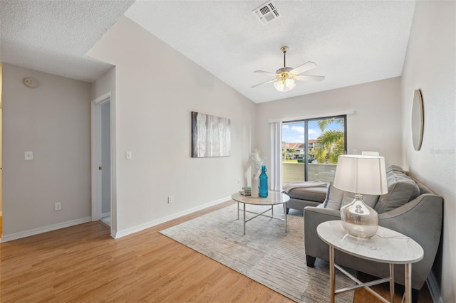 2387 Hanover Dr Unit 2387, Dunedin, FL 34698 - sitting room with a ceiling fan, a textured ceiling, light wood-type flooring, baseboards, and vaulted ceiling