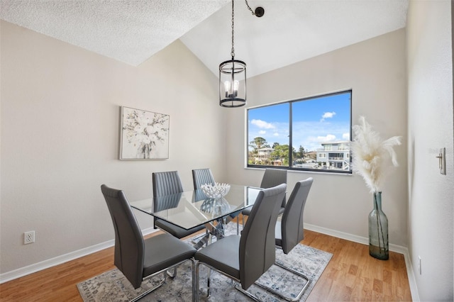 2387 Hanover Dr Unit 2387, Dunedin, FL 34698 - dining space with a chandelier, vaulted ceiling, baseboards, and wood finished floors