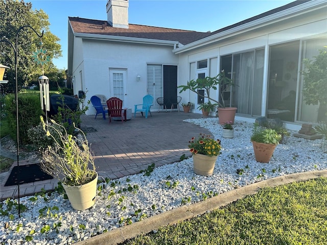 14334 Teasdale Ave, Hudson, FL 34667 - rear view of property with a patio, a chimney, a shingled roof, and stucco siding