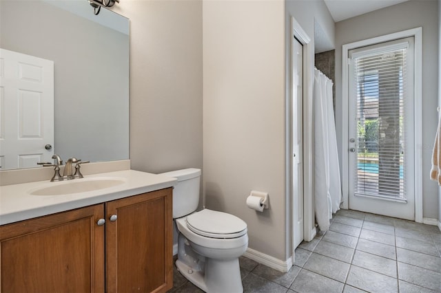 bathroom with toilet, vanity, baseboards, and tile patterned flooring