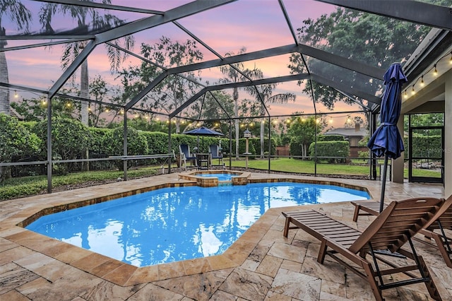 view of pool with a pool with connected hot tub, a patio, and a lanai