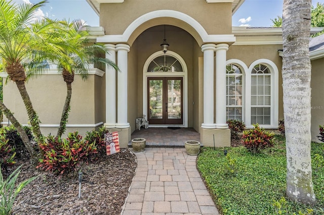 entrance to property featuring french doors and stucco siding