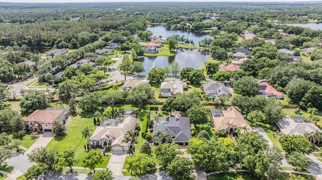 bird's eye view featuring a wooded view, a residential view, and a water view