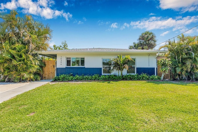 ranch-style home with a front yard, fence, and stucco siding