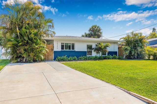 ranch-style house with a front yard, fence, stucco siding, brick siding, and a gate