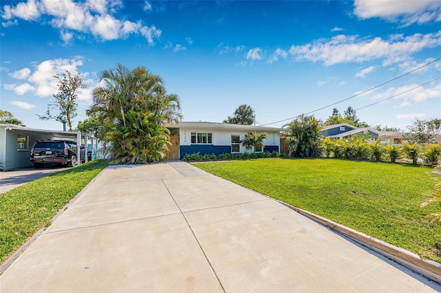 ranch-style house with a front yard, stucco siding, an attached carport, and concrete driveway