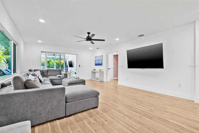 living area with light wood-type flooring, baseboards, a ceiling fan, and recessed lighting