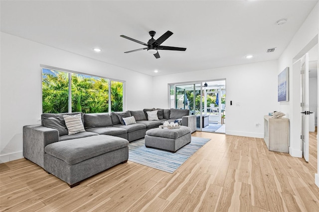 living room with light wood-style flooring, a ceiling fan, recessed lighting, and baseboards
