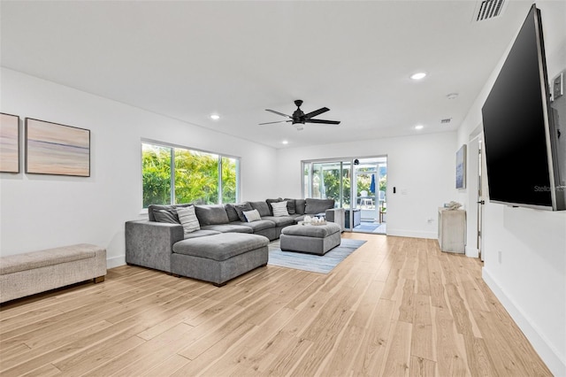 living area with light wood-type flooring, baseboards, recessed lighting, visible vents, and ceiling fan