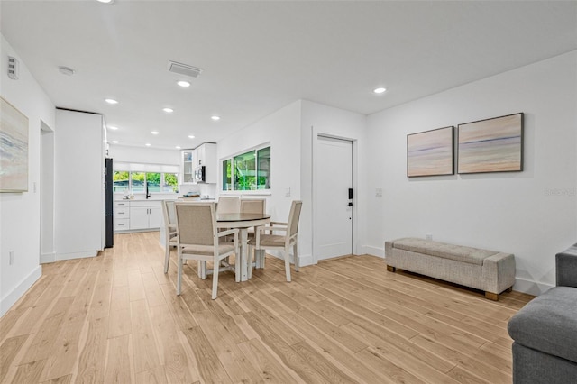 dining room with recessed lighting, light wood-style flooring, and baseboards