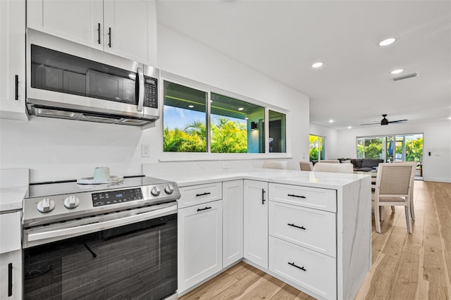 kitchen featuring visible vents, light wood-type flooring, appliances with stainless steel finishes, white cabinetry, and recessed lighting