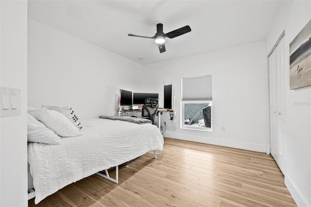 bedroom featuring wood finished floors, baseboards, and a ceiling fan