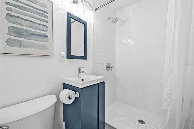 bathroom featuring toilet, vanity, and a shower stall