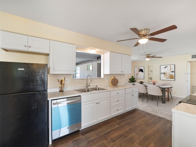 kitchen with light countertops, freestanding refrigerator, white cabinets, dishwasher, and a sink