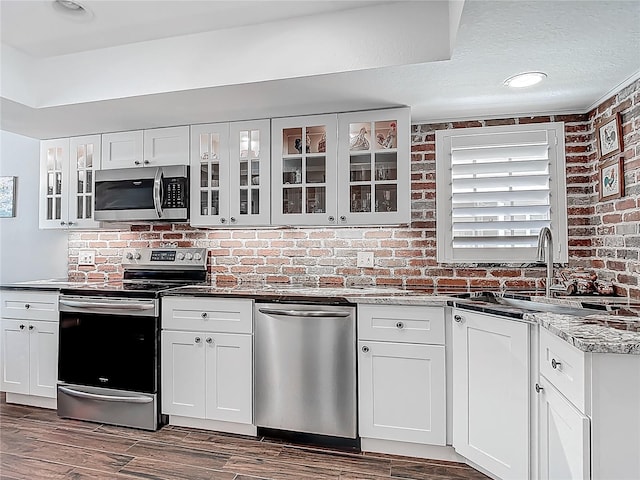 3611 Pine Knot Dr, Valrico, FL 33596 - kitchen with glass insert cabinets, stainless steel appliances, a sink, white cabinetry, and dark wood-style floors
