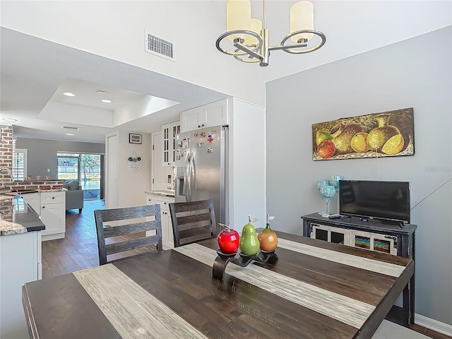 3611 Pine Knot Dr, Valrico, FL 33596 - dining space with visible vents, wood finished floors, a chandelier, and a tray ceiling