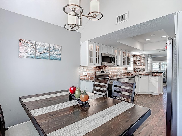 3611 Pine Knot Dr, Valrico, FL 33596 - dining room with recessed lighting, an inviting chandelier, a tray ceiling, visible vents, and baseboards