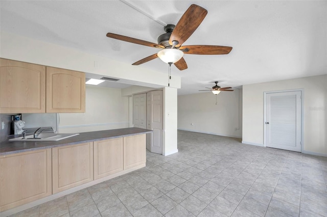 1655 S Highland Ave Unit D140, Clearwater, FL 33756 - kitchen with light brown cabinets, a sink, ceiling fan, dark countertops, and baseboards