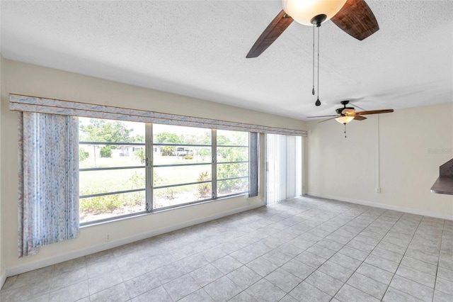 1655 S Highland Ave Unit D140, Clearwater, FL 33756 - empty room with ceiling fan, plenty of natural light, a textured ceiling, light tile patterned floors, and baseboards