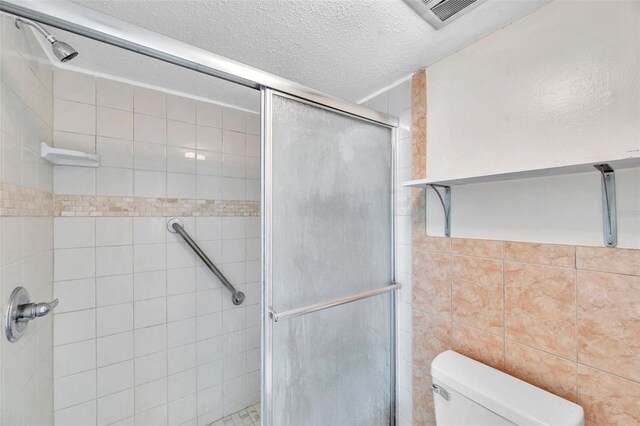 1655 S Highland Ave Unit D140, Clearwater, FL 33756 - full bathroom with a shower stall, toilet, and a textured ceiling