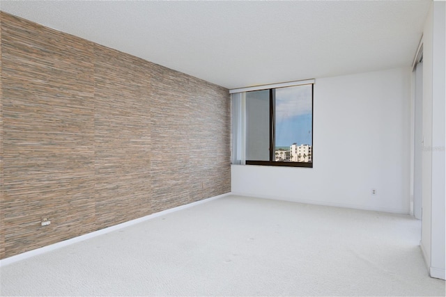 carpeted spare room featuring baseboards