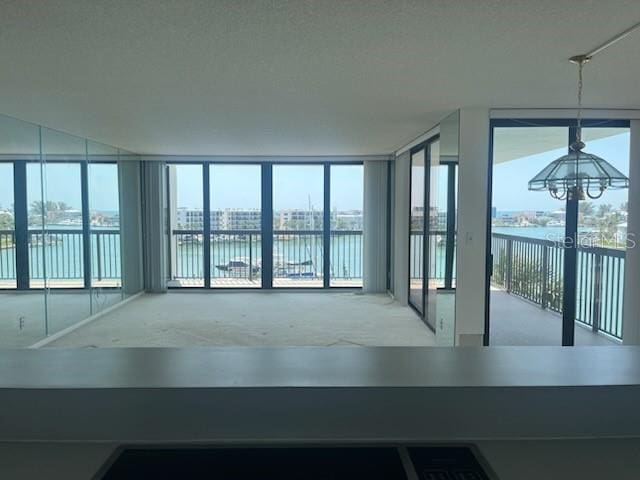 interior space featuring a wealth of natural light, floor to ceiling windows, and a water view