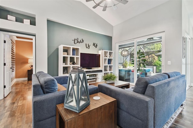 living area with high vaulted ceiling, ceiling fan, baseboards, and wood finished floors