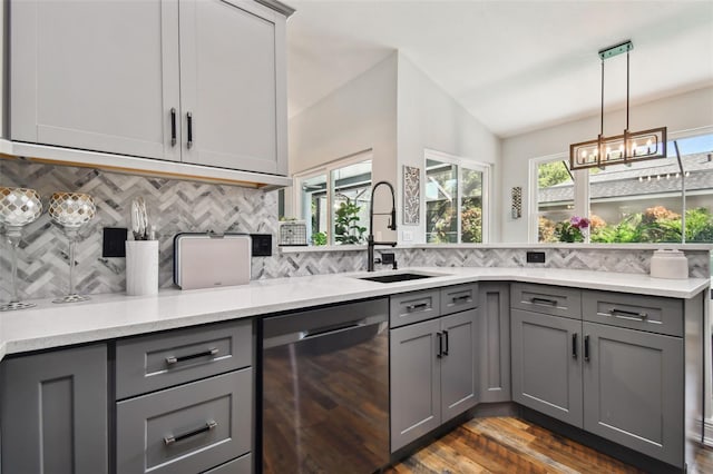 kitchen featuring a sink, stainless steel dishwasher, gray cabinetry, and backsplash