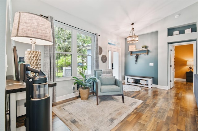 sitting room featuring a notable chandelier, baseboards, and wood finished floors