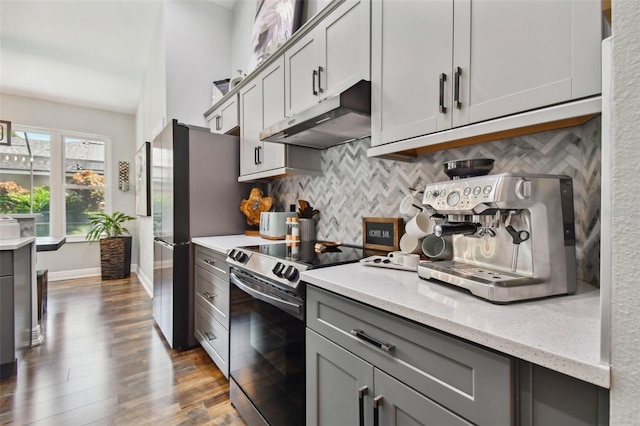 kitchen with tasteful backsplash, under cabinet range hood, gray cabinetry, and appliances with stainless steel finishes
