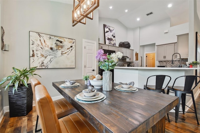 dining room with visible vents, baseboards, recessed lighting, wood finished floors, and high vaulted ceiling
