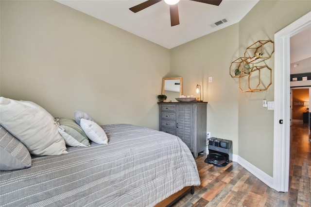 bedroom with visible vents, baseboards, a ceiling fan, vaulted ceiling, and wood finished floors