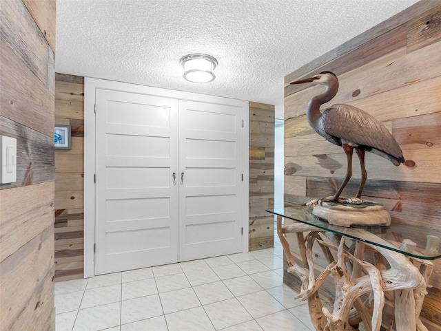 1430 Gulf Blvd Unit 102, Clearwater Beach, FL 33767 - dining area featuring light tile patterned flooring, a textured ceiling, and wood walls