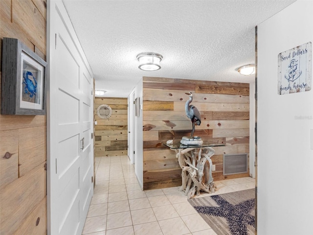 1430 Gulf Blvd Unit 102, Clearwater Beach, FL 33767 - hallway featuring light tile patterned flooring, a textured ceiling, wood walls, and visible vents