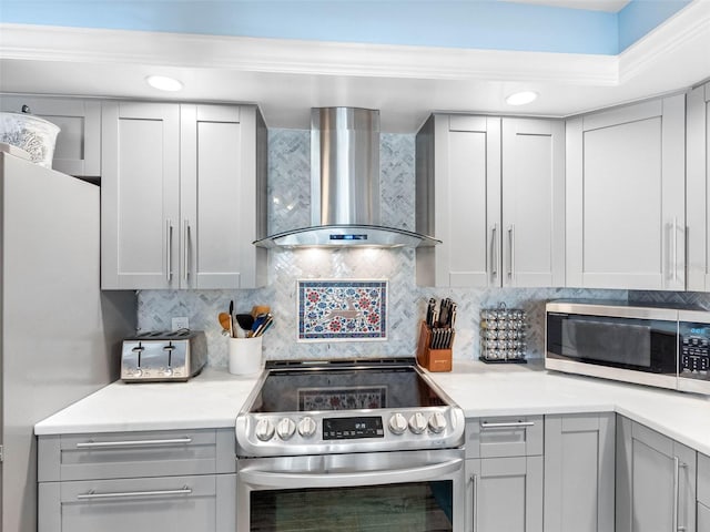 1430 Gulf Blvd Unit 102, Clearwater Beach, FL 33767 - kitchen with stainless steel appliances, light countertops, wall chimney exhaust hood, and backsplash