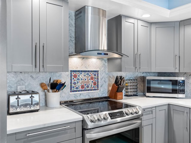 1430 Gulf Blvd Unit 102, Clearwater Beach, FL 33767 - kitchen featuring tasteful backsplash, gray cabinets, wall chimney exhaust hood, and appliances with stainless steel finishes