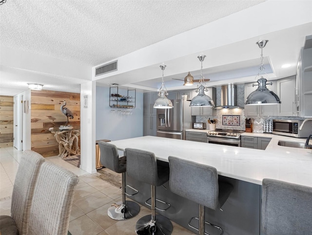 1430 Gulf Blvd Unit 102, Clearwater Beach, FL 33767 - kitchen with wall chimney exhaust hood, gray cabinets, a sink, light countertops, and stainless steel appliances