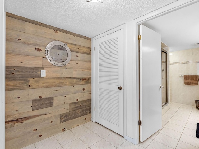 1430 Gulf Blvd Unit 102, Clearwater Beach, FL 33767 - hallway featuring wood walls, light tile patterned floors, and a textured ceiling