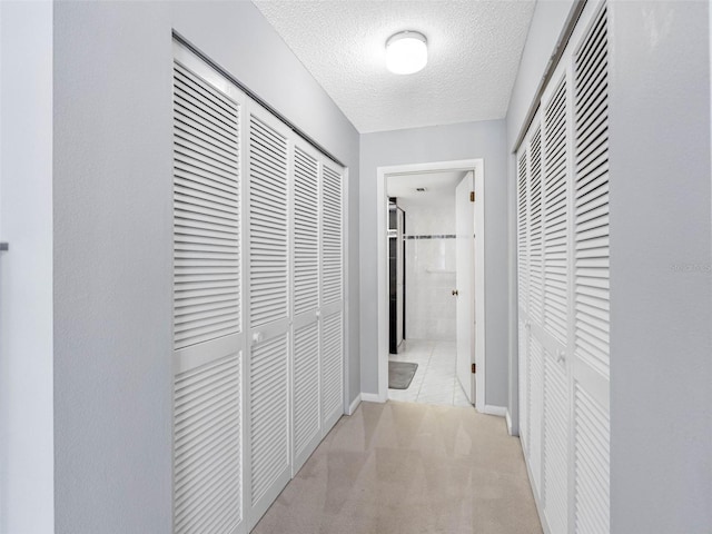 1430 Gulf Blvd Unit 102, Clearwater Beach, FL 33767 - hall featuring carpet flooring, a textured ceiling, and baseboards