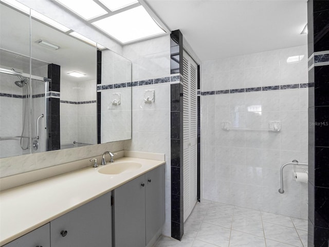 1430 Gulf Blvd Unit 102, Clearwater Beach, FL 33767 - bathroom featuring a shower stall, marble finish floor, vanity, and tile walls