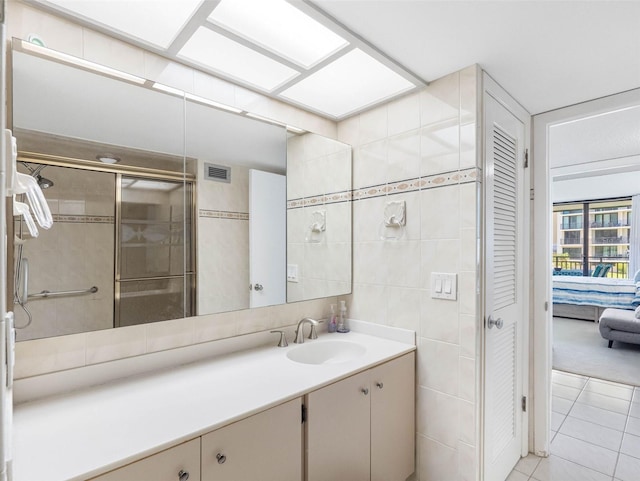 1430 Gulf Blvd Unit 102, Clearwater Beach, FL 33767 - bathroom featuring vanity, a stall shower, tile patterned floors, visible vents, and tile walls