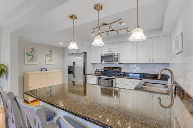 1460 Gulf Blvd Unit 406, Clearwater Beach, FL 33767 - kitchen with a peninsula, white cabinetry, a sink, hanging light fixtures, and stainless steel appliances