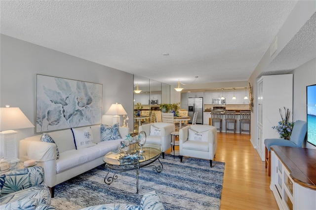 1460 Gulf Blvd Unit 406, Clearwater Beach, FL 33767 - living area with light wood-type flooring, visible vents, and a textured ceiling